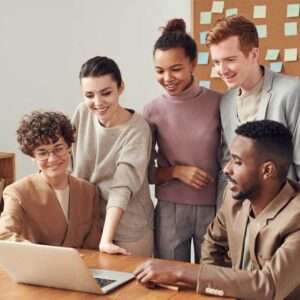 Diverse group of professionals collaborating around a laptop
