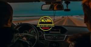 Driver inside car with Ablaze Driving School logo