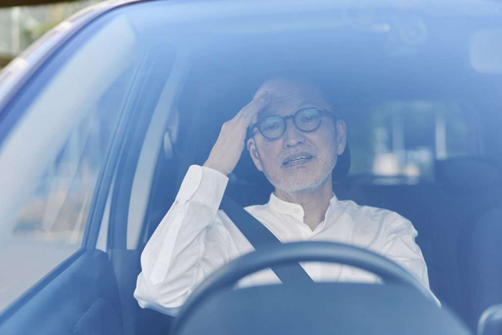 Elderly man stressed while driving in car
