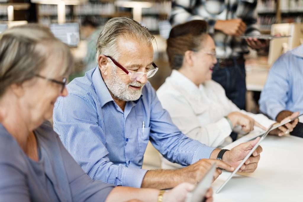 Seniors using tablets in a library