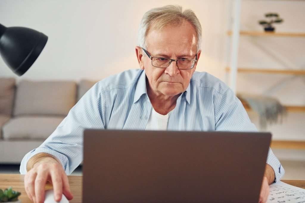 Senior man concentrating on laptop in home office